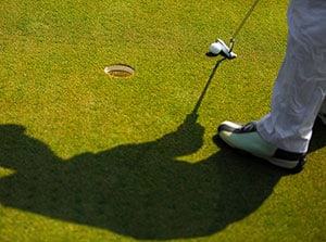 golfer using a short putter